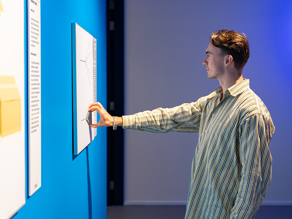 A young man interacts with the Angle Illusion on the wall at Museum of Illusions Manchester.