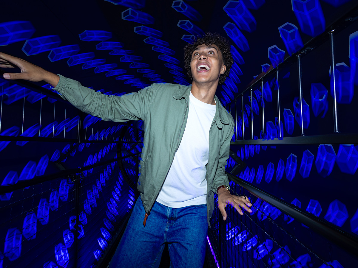 A young man is having fun while passing through the Vortex Tunnel at Museum of Illusions Manchester.