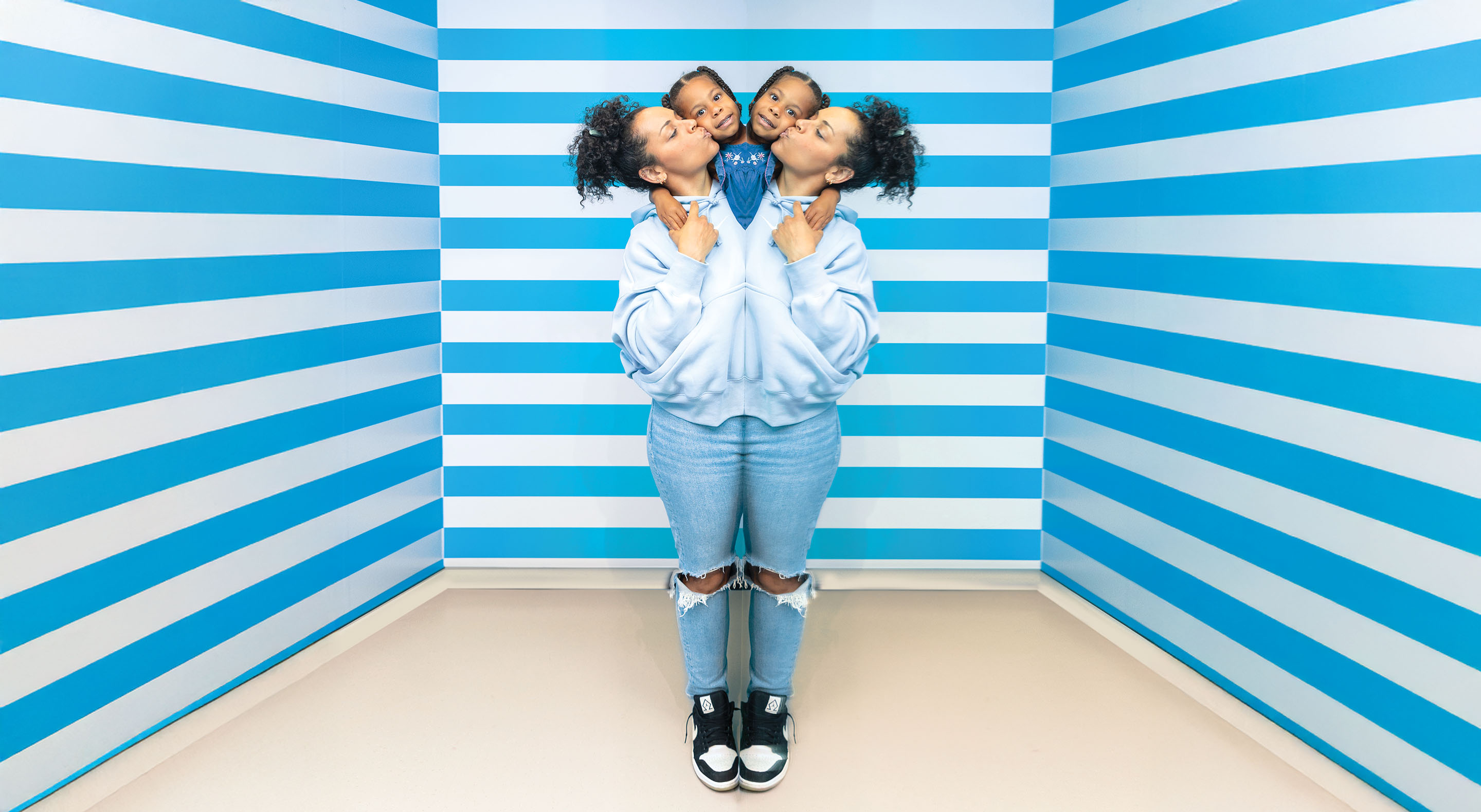 A woman and a child in the Symmetry Room appear to have one body and four heads.