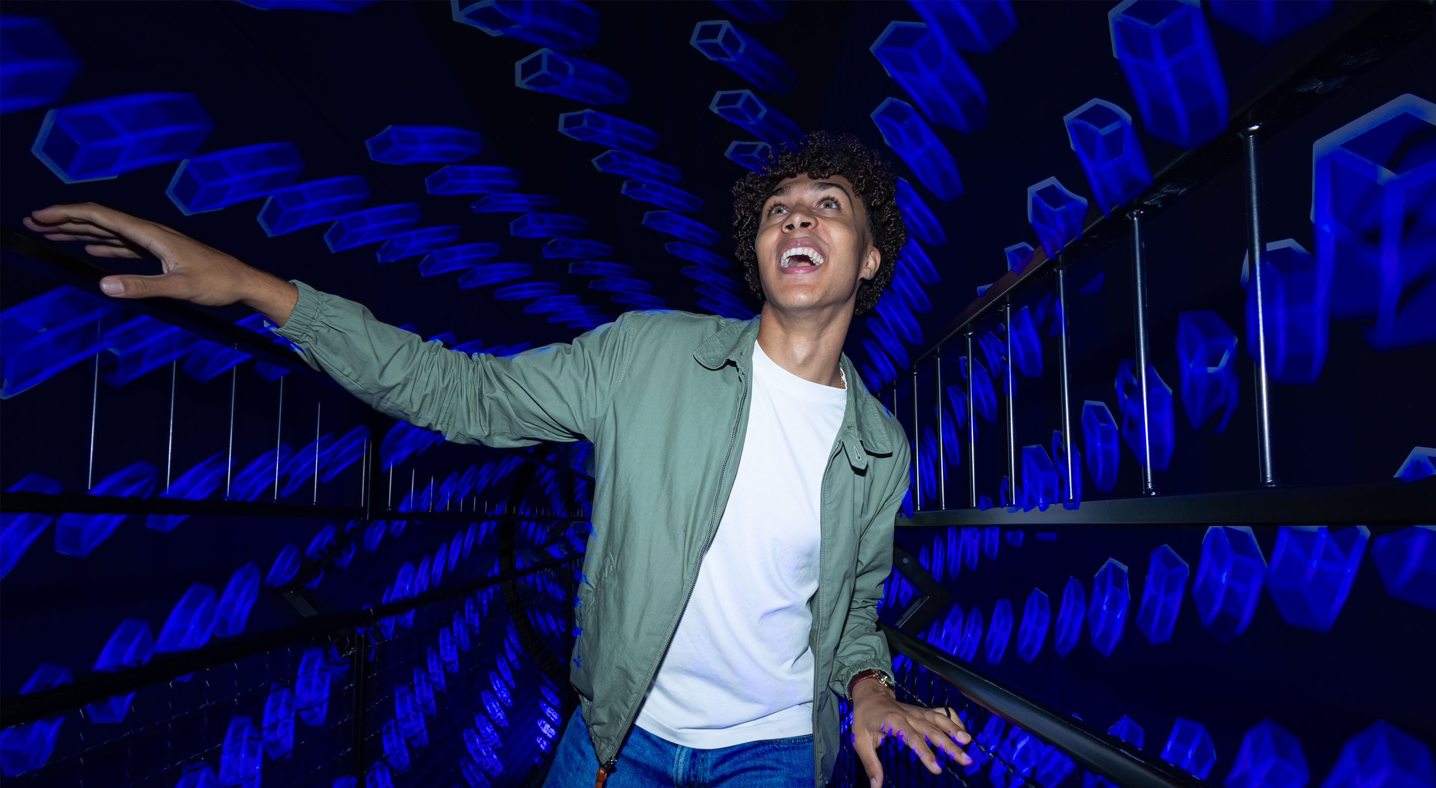 A young man is smiling as he passes through the Museum of Illusions Vortex Tunnel.