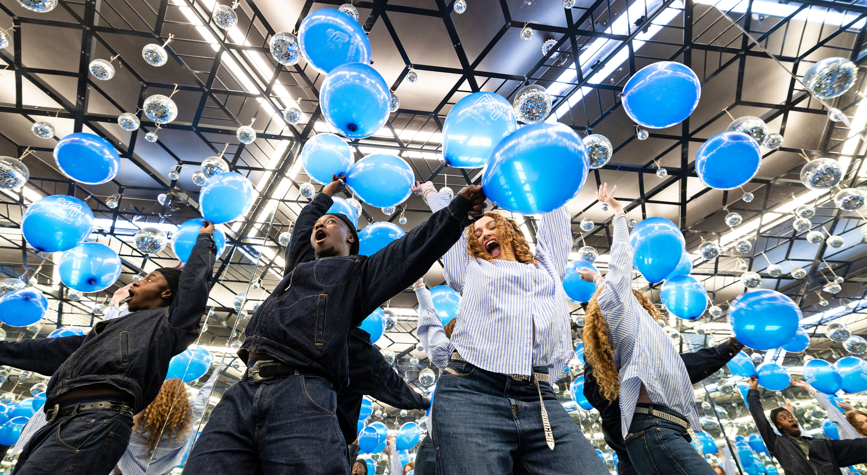 Young people holding balloons and having fun in the Infinity Room at Museum of Illusions.