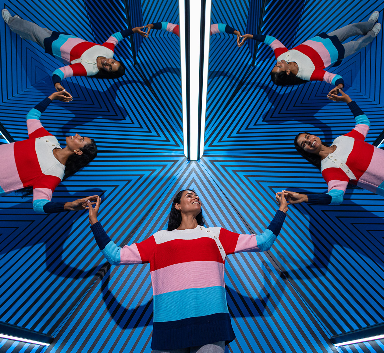 A woman stands in the Clone Room, surrounded by four reflections of herself in the mirrors.