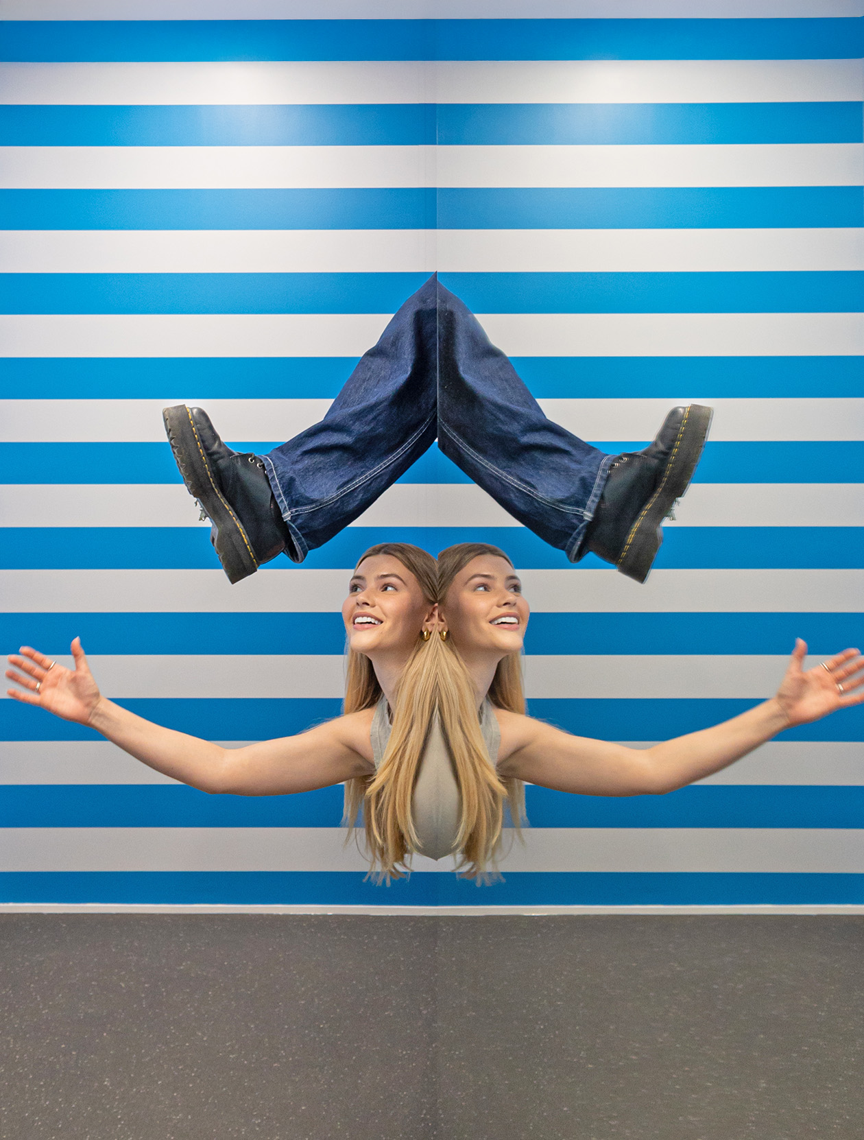 In the Symmetry Room illusion, a woman appears to have two heads with a pair of legs floating above them.