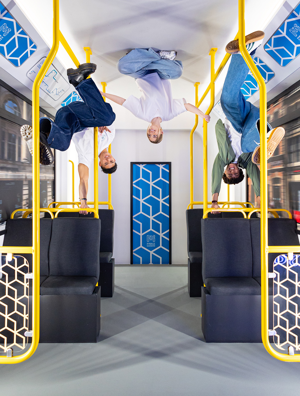 Visitors appear to defy gravity as they sit upside down at Museum of Illusions Reversed Room.